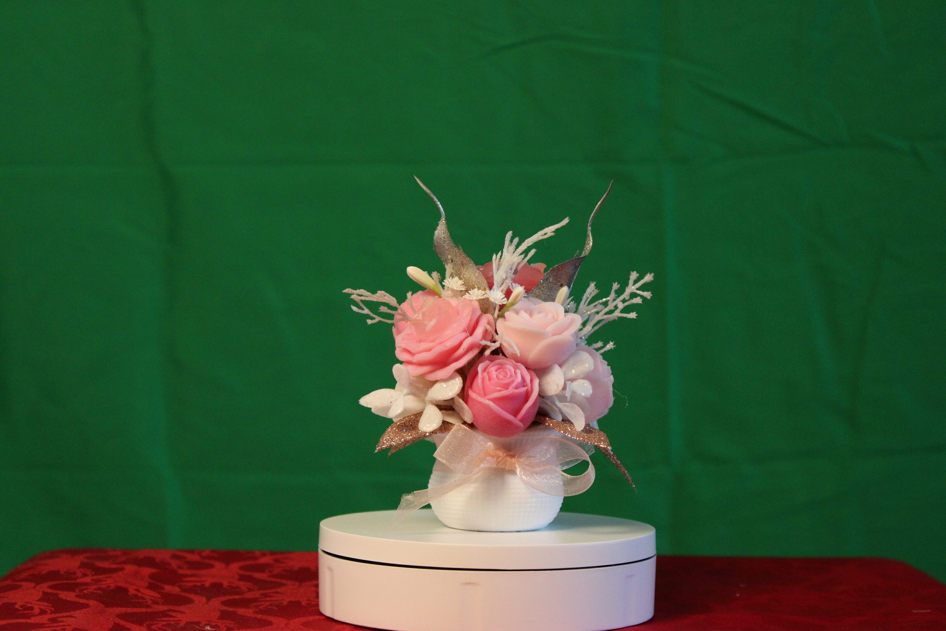 Pink rose bouquet in white vase on platform