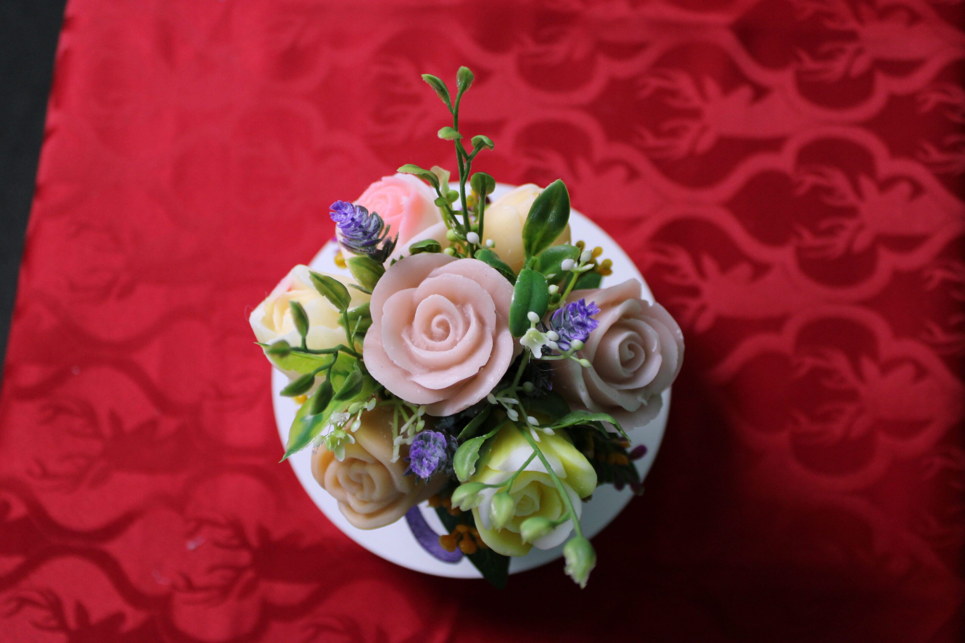 Pastel rose bouquet on red patterned fabric