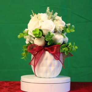 White floral arrangement in vase with red bow