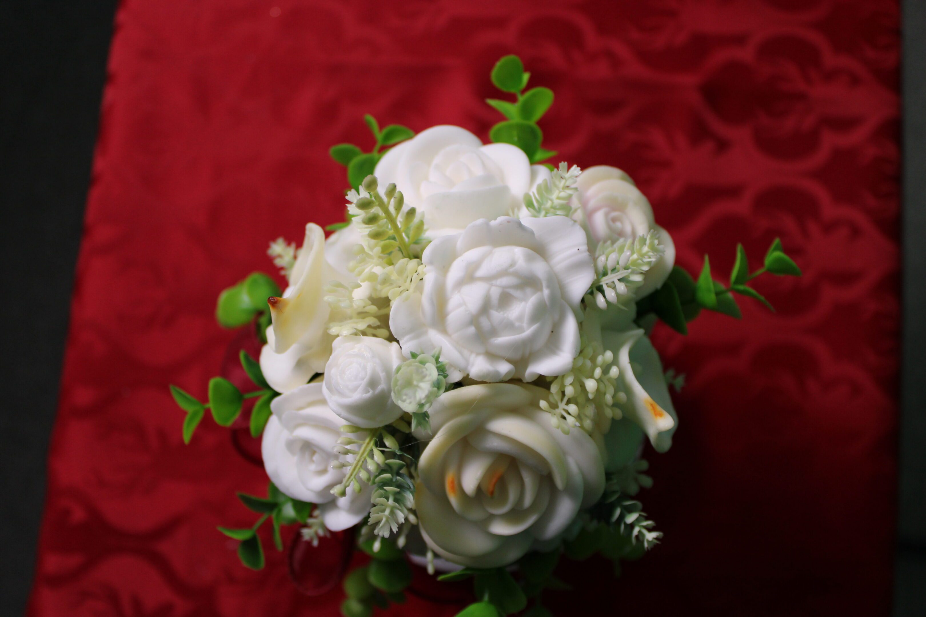 White rose bouquet on red patterned fabric