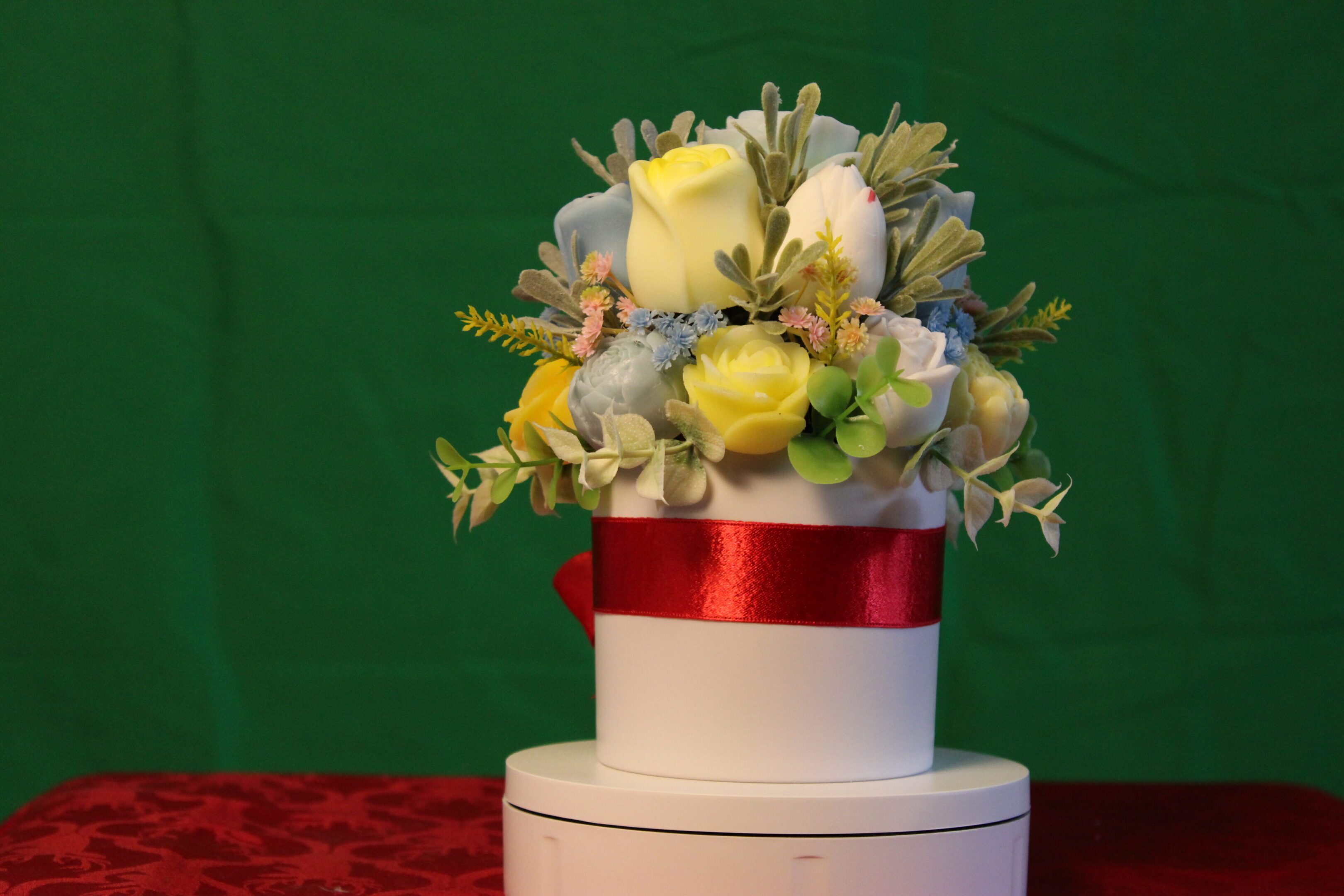 White round gift box with ribbon and flowers