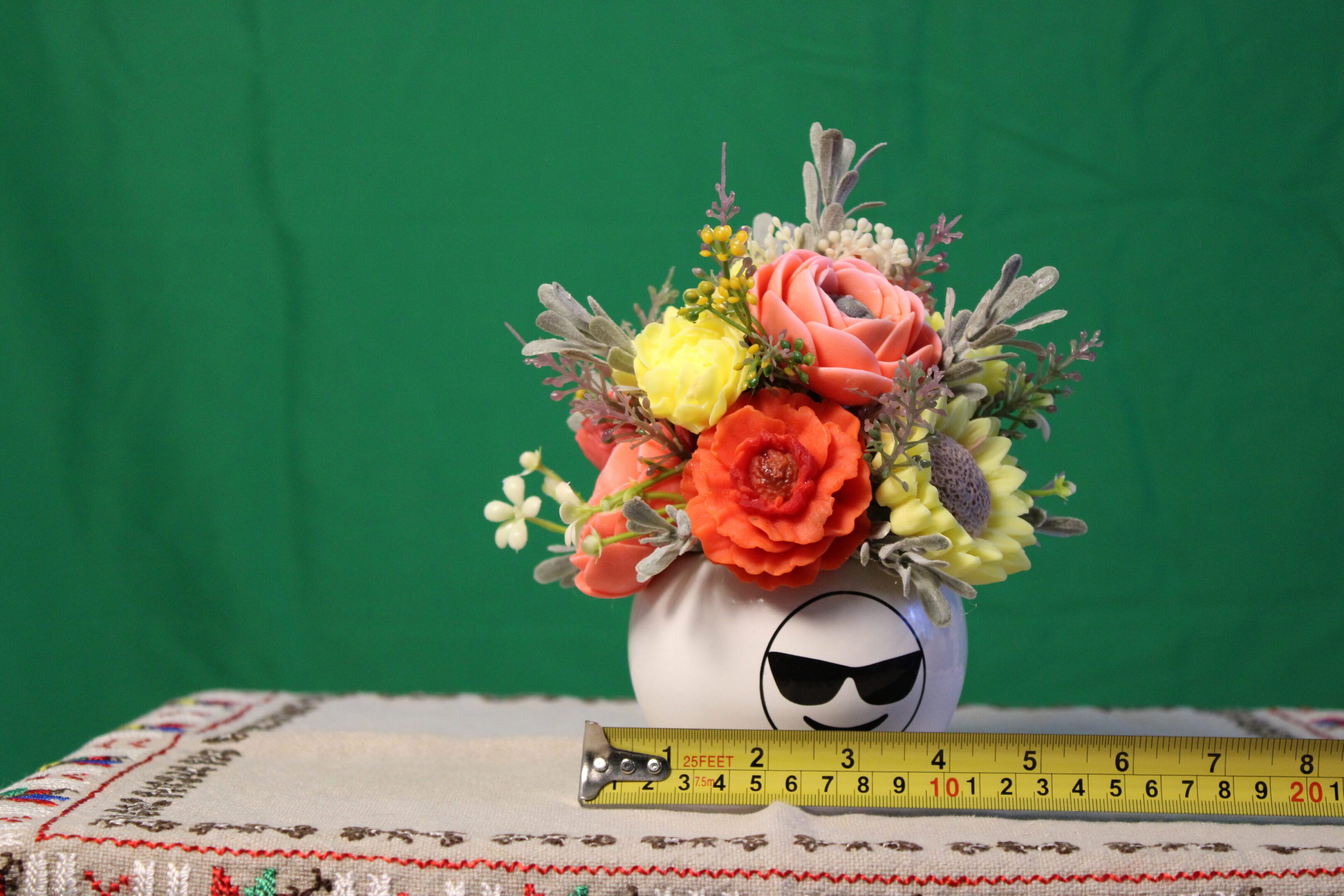 Colorful bouquet in vase with sunglasses face
