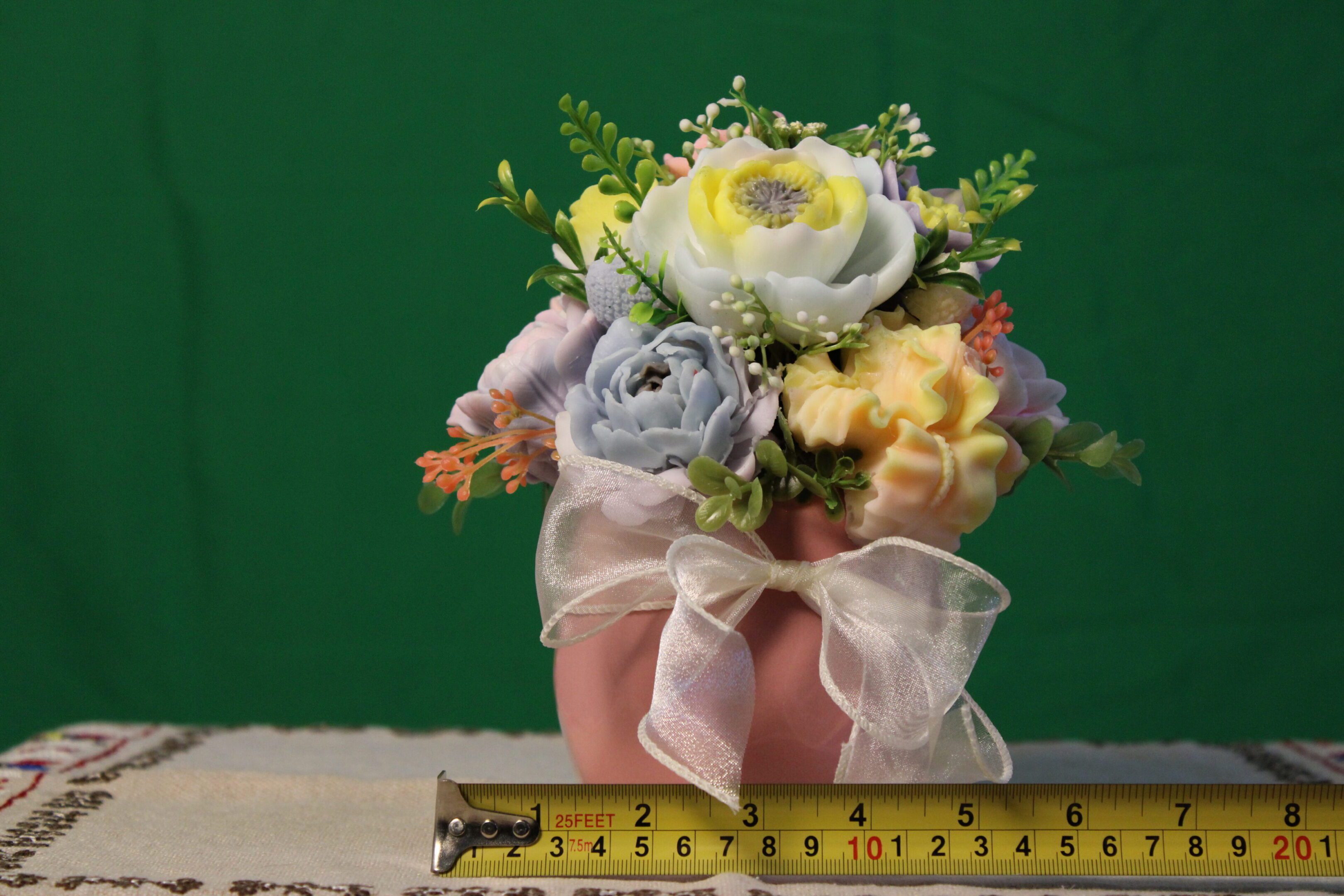 Pink vase with silk flowers and measuring tape