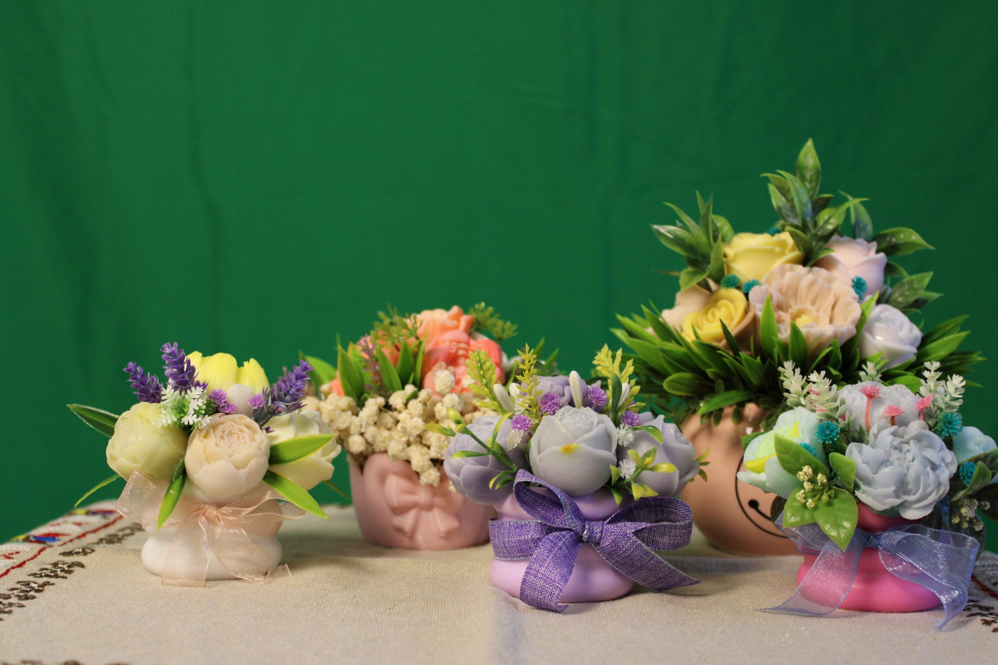 Small pastel floral arrangements in decorative pots