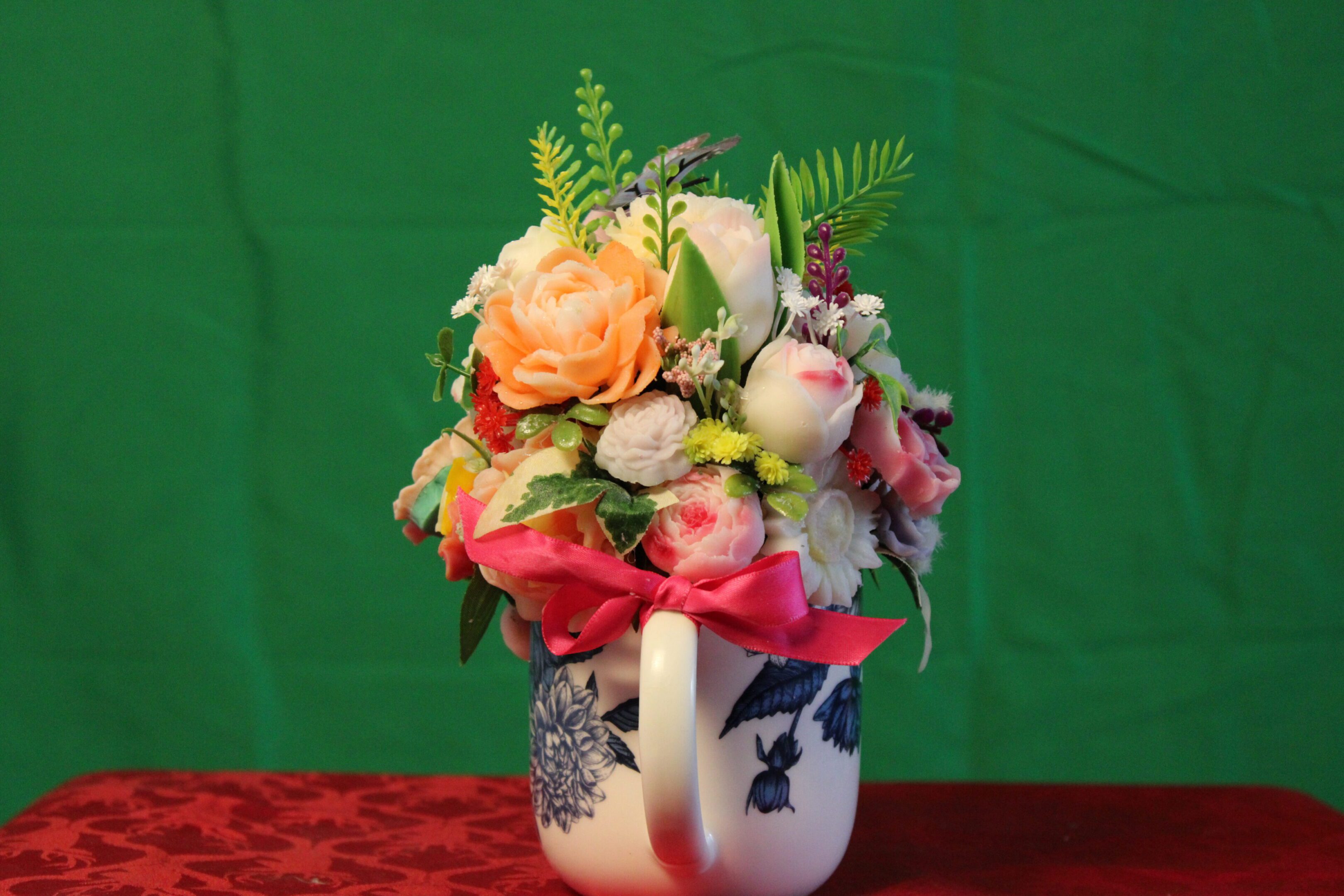 Colorful flower arrangement in ribboned ceramic mug