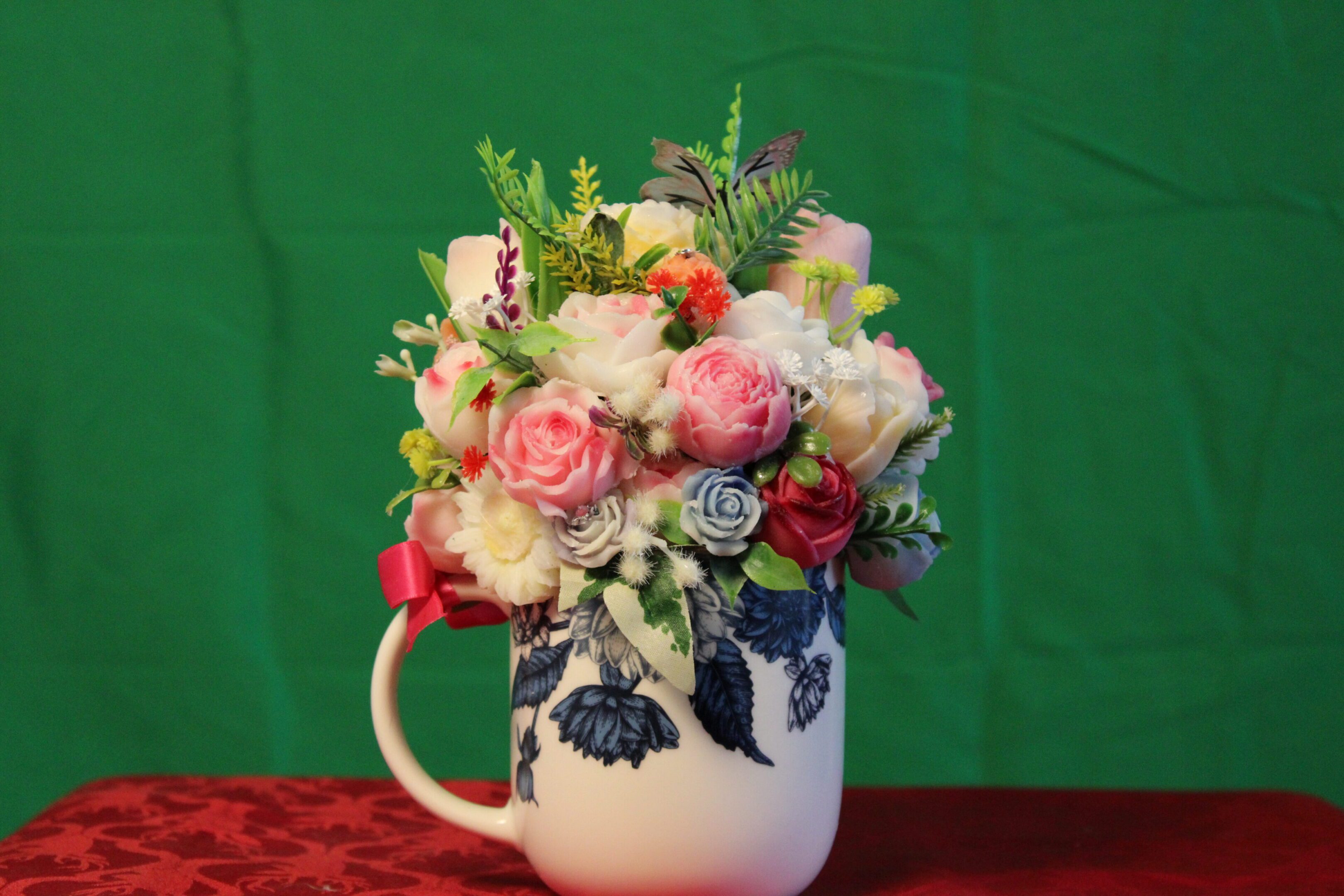 Pink rose bouquet in patterned ceramic mug