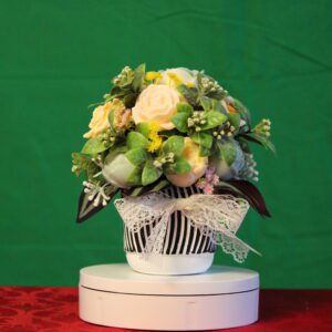 Floral arrangement in white pot with lace