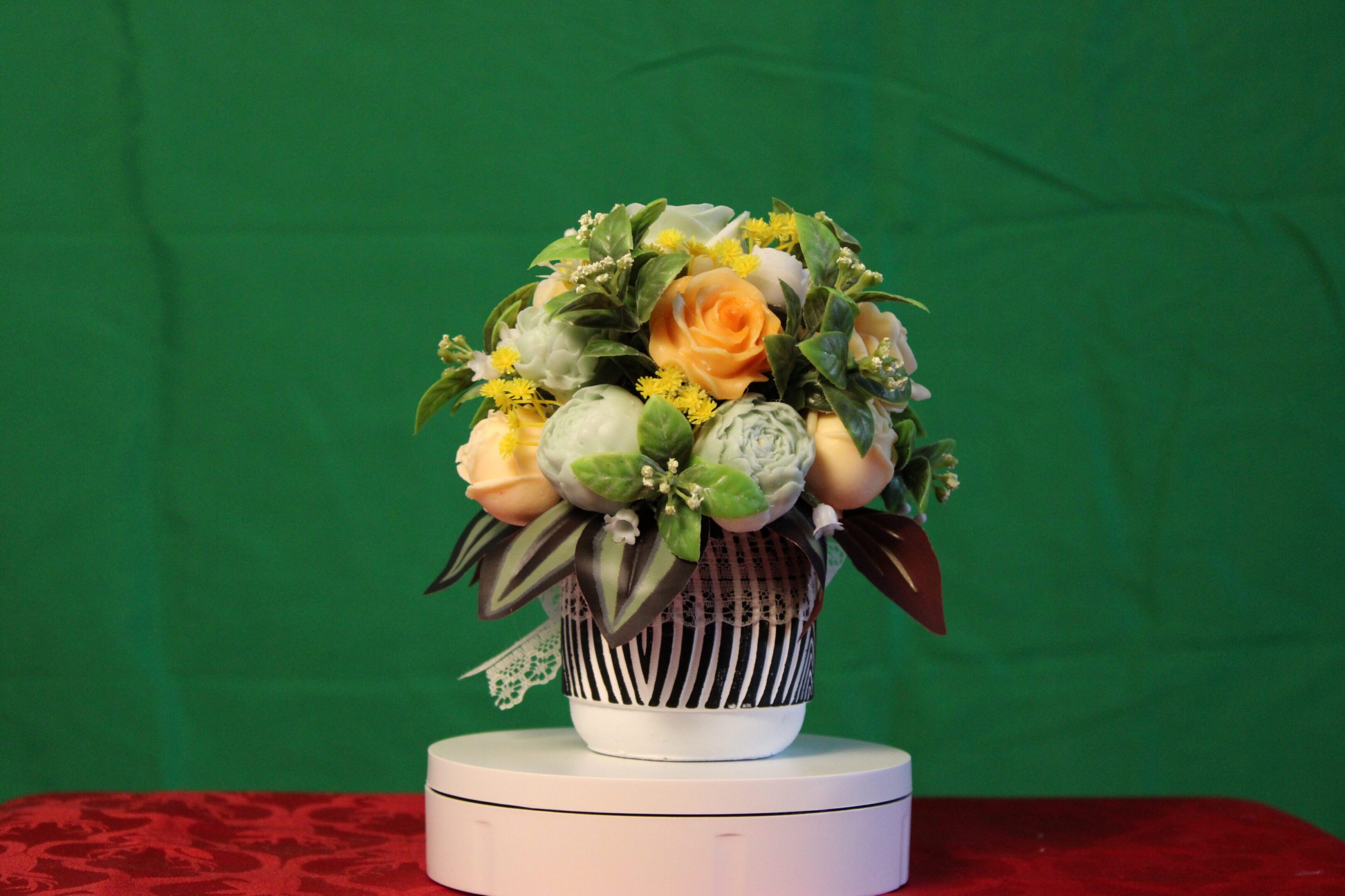 Yellow and white floral arrangement in striped vase